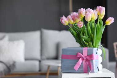 Uluslararası Kadınlar Günü için laleli vazo ve hediye kutusu oturma odasında, yakın plan.