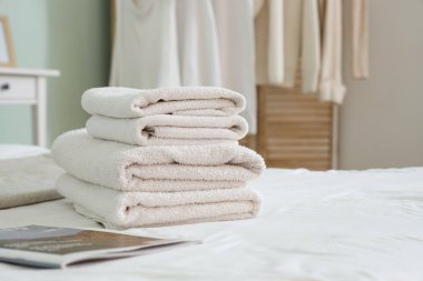 Yatak odasında temiz havlu ve şarjör yığını, yakın plan.