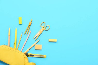 Mavi arka planda kırtasiye malzemesi olan kalem kutusu. Üst görünüm