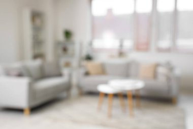 Kanepe ve sehpası olan, bulanık manzaralı bir oturma odası.