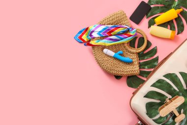 Pembe arka planda bavul, plaj aksesuarları, vibratör ve cep telefonu kompozisyonu