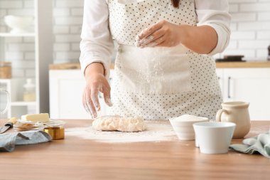 Kadın mutfakta geleneksel tarçınlı rulo hazırlıyor.