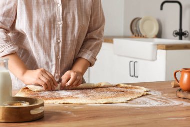 Kadın mutfakta geleneksel tarçınlı rulo hazırlıyor.