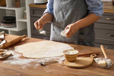 Kadın mutfakta geleneksel tarçınlı rulo hazırlıyor.