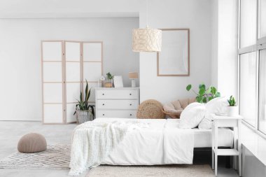 Çekmeceli, komodinli ve yataklı aydınlık yatak odasının modern iç mekanı.