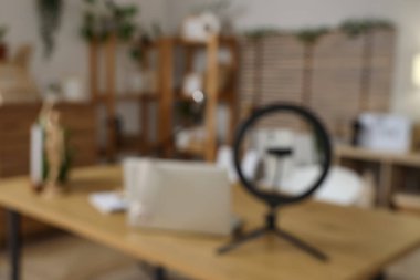 Podcaster 'ın atölyesindeki dizüstü bilgisayar ve halka ışığının bulanık görüntüsü