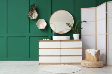 Lavabosu, aynası ve katlanabilir ekranı olan banyonun içi.