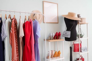 Manken, elbise askılığı ve raf üniteleri olan soyunma odasının içinde.