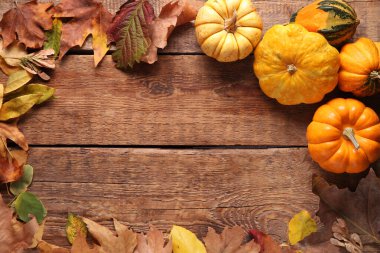 Taze balkabaklarından yapılmış çerçeve ve ahşap arka planda sonbahar yaprakları