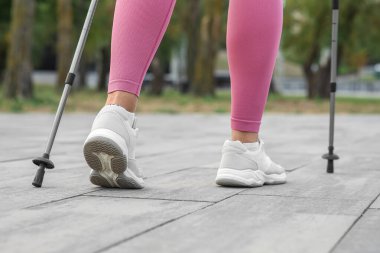 Sportif kadın İskandinav yürüyüşü yapıyor.