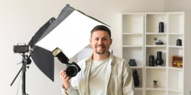 Stüdyoda profesyonel kamerası olan yakışıklı bir fotoğrafçı.
