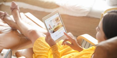 Otelde tablet bilgisayarlı rezervasyon odası olan bir kadın.