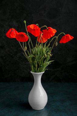 Koyu arkaplanda güzel gelincik çiçekleri olan vazo. Anma Günü