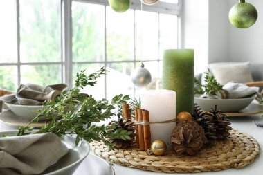 Yanan mumlar ve kozalaklı Noel sofrası, yakın plan.