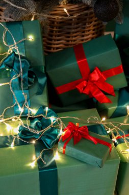 Kırmızı kurdeleli yeşil kağıda sarılı Noel hediyeleri.