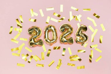 2024 numaralı altın folyo balonları ve pembe arka planda konfeti. Yeni yıl kavramı.