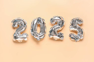 Turuncu arka planda balonlardan yapılmış 2024 numaralı figür.