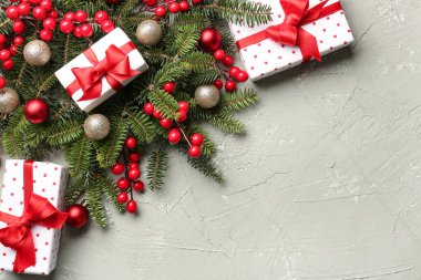 Topları, Rowan 'ı ve gri arka planda hediye kutuları olan Noel ağacı dalları