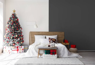 Konforlu yatağı ve Noel ağacı olan şenlikli bir yatak odası.