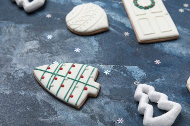 Koyu renkli arka planda lezzetli Noel kurabiyeleri ve dekorasyonlar