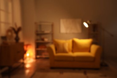 Oturma odasının bulanık görüntüsü, kanepe ve gece lambaları.