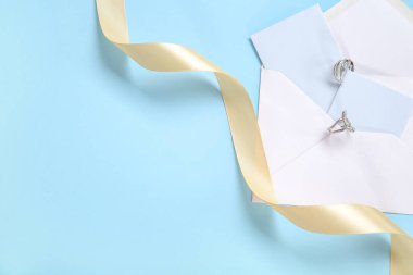 Tebrik kartı, yüzük ve mavi arkaplanda altın kurdele.