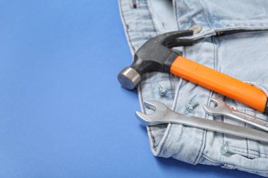 Mavi arka planda kot pantolon cebinde araçlar. İşçi Bayramı kutlamaları