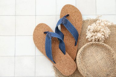 Beyaz fayanslı hasır şapkalı ve mercanlı parmak arası terlikler.