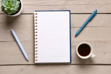 Kalemli defter ve gri ahşap arka planda bir fincan lezzetli kahve.