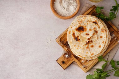 Tahta tahtada beyaz arka planda lezzetli pita ekmeği ve un