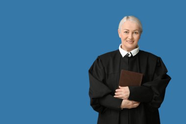 Mavi arka plan kitabı olan olgun bir kadın yargıç.