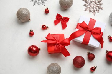 Hediye kutularıyla Noel baloları ve beyaz arka planda eğilme