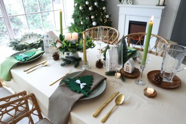 Oturma odasında Noel ağacı ve şöminesi olan şölen masası.