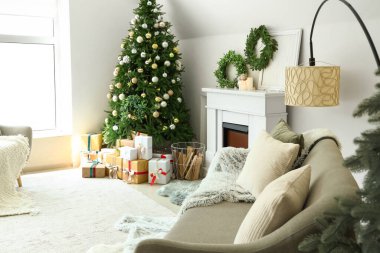 Noel ağacı ve şöminesi olan şenlikli oturma odasının içinde.