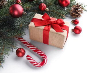 Beyaz arka planda hediye kutusu, koni ve süslemeleri olan Noel ağacı dalları
