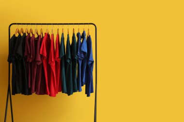 Sarı arka planda farklı tişörtler. Kara Cuma indirimi