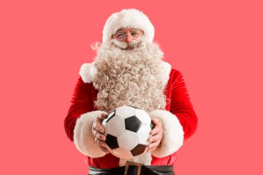 Kırmızı arka planda futbol topu olan Noel Baba.