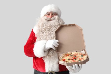 Beyaz arka planda bir kutu lezzetli pizza olan Noel Baba.