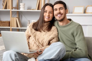 Sevgili çift kış günü evde dizüstü bilgisayar kullanıyor.