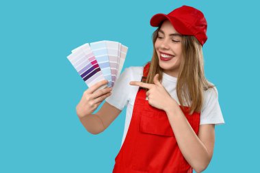 Mavi arkaplanda renk paletlerini gösteren kadın ressam