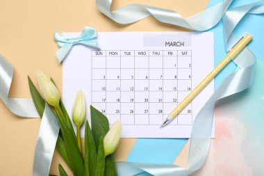 Renkli arka planda kalem ve kurdeleli takvim. Uluslararası Kadınlar Günü kutlamaları