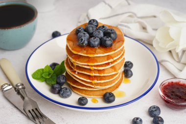 Lezzetli gözleme tabağı, çay ve çatal bıçak takımı beyaz masada.