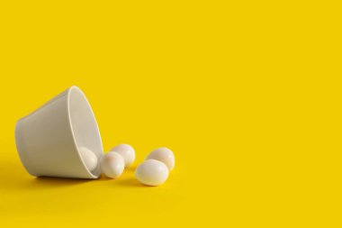 Sarı arka planda taze kaynamış bıldırcın yumurtası kasesi.