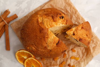 Tarçınlı panettone ve parşömen üzerinde bir dilim portakal. Üst görünüm