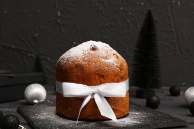 Siyah zemin üzerine pudra şekeri serpiştirilmiş Panettone