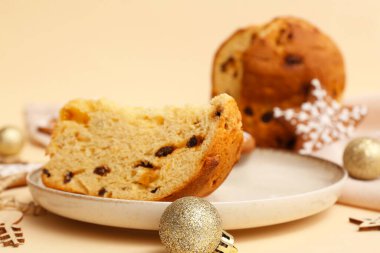 Bir parça Panettone tabağı ve bej arka planda Noel dekoru