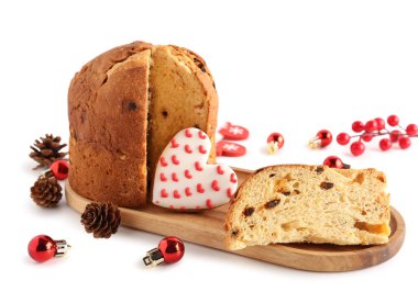 Kesik Panettone, kurabiye, koni ve beyaz arka planda Noel topları olan tahta tepsi.