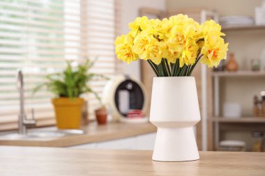 Mutfaktaki masada güzel narsisus çiçekleri olan vazo.