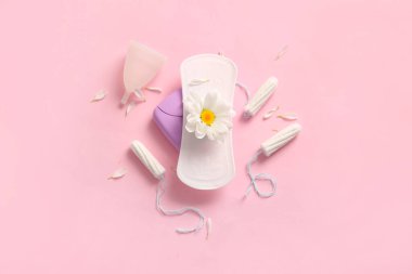 Pembe arka planda pedli, tamponlu ve papatya çiçekli regl bardağı