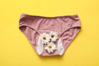 Sarı arka planda papatya çiçekli iç çamaşırı.